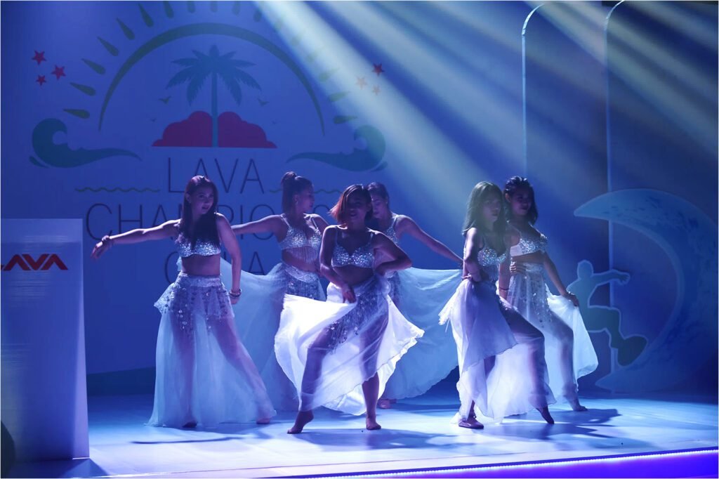 Dancers perform on a blue-lit stage
