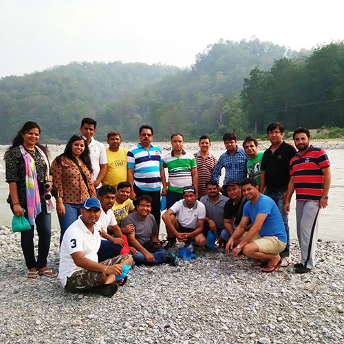 Guests gathered on a riverbank among hills