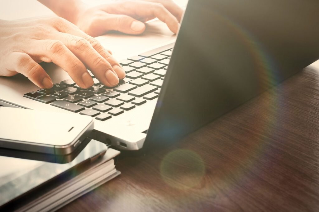 Hands working on a laptop